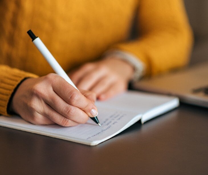 Image of someone writing in a notebook.