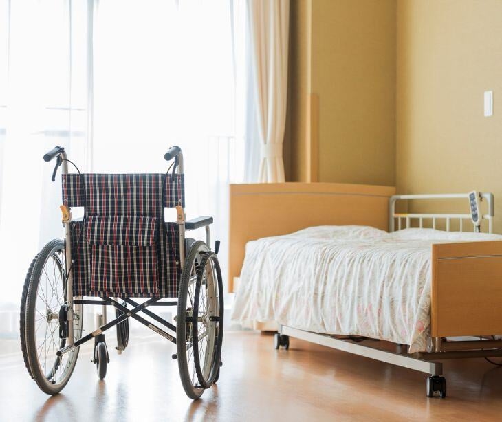 nursing home room with bed and wheelchair