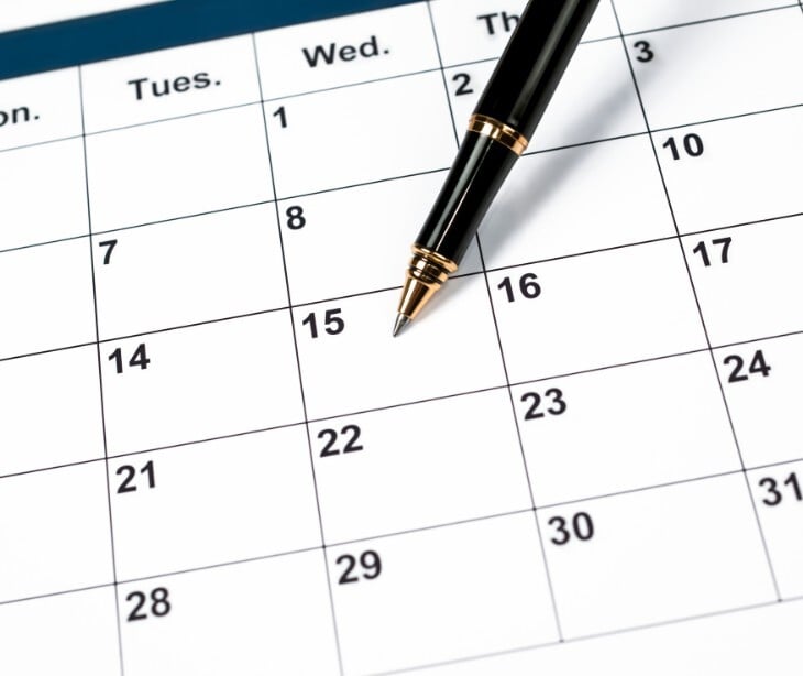 Image of a calendar and a pen. 