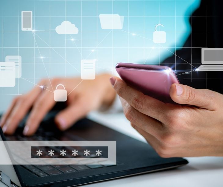 floating security icons over laptop with phone