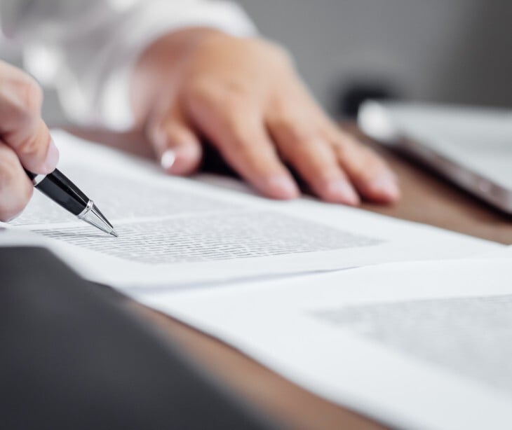 Image of someone signing a document. 