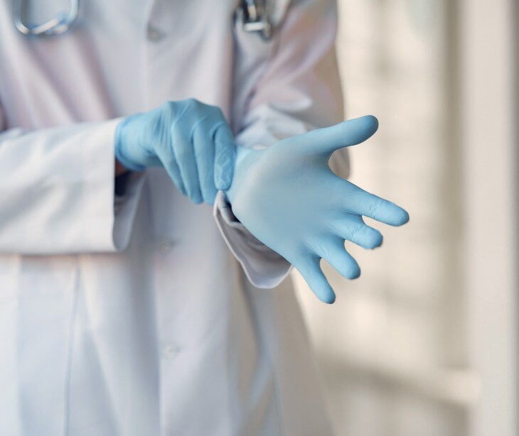 Image of a doctor putting on gloves.