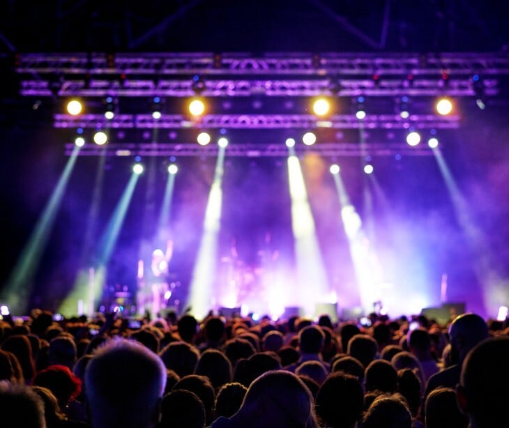 Imageof  a large, lit up stadium with people watching a show. 