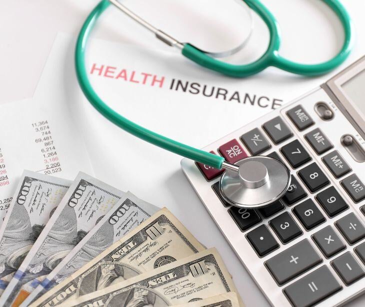 health insurance money paperwork calculator and stethoscope