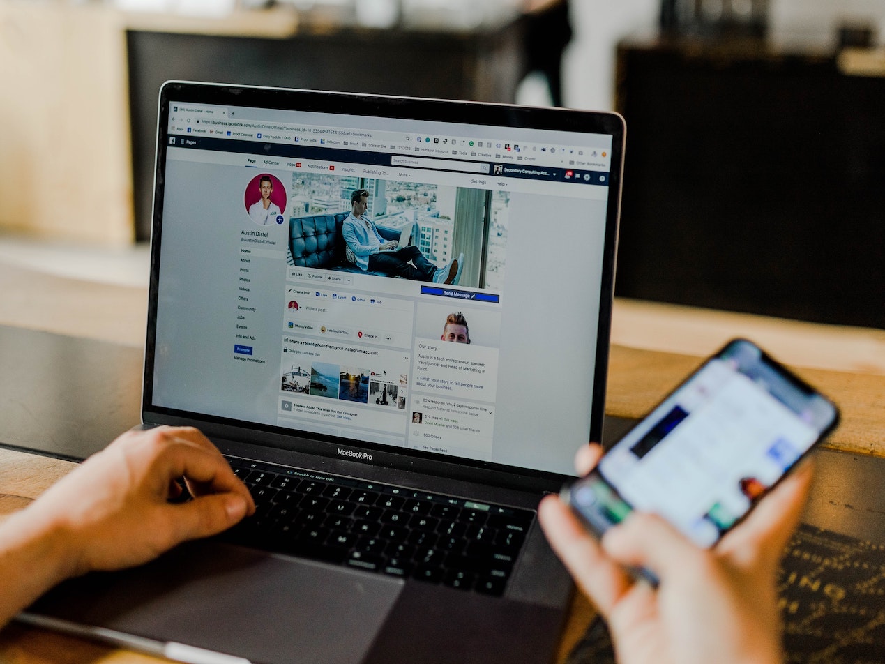 computer screen and smartphone on facebook page