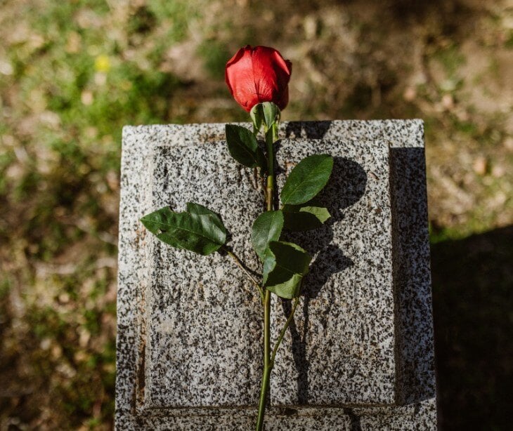 Image of gravestone with pink rose.