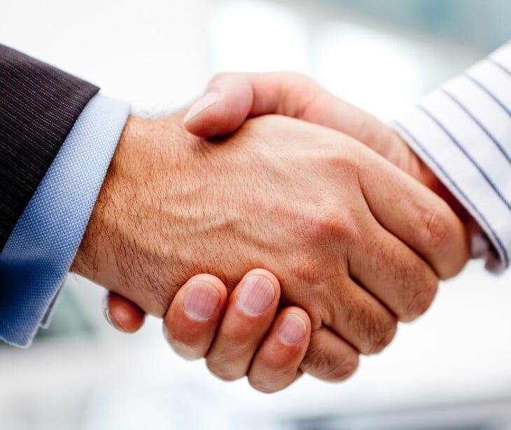 Image of two individuals shaking hands. 