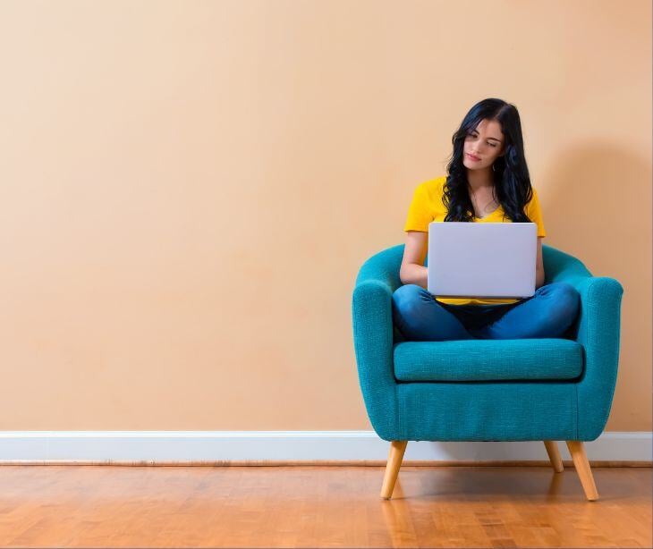 woman sitting on laptop for post Online psychotherapy's promise and perils