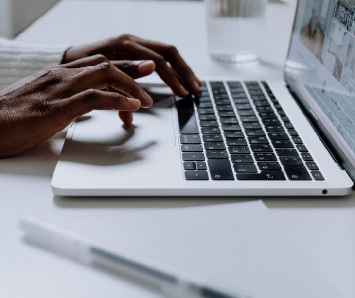 Image of person typing on a laptop.
