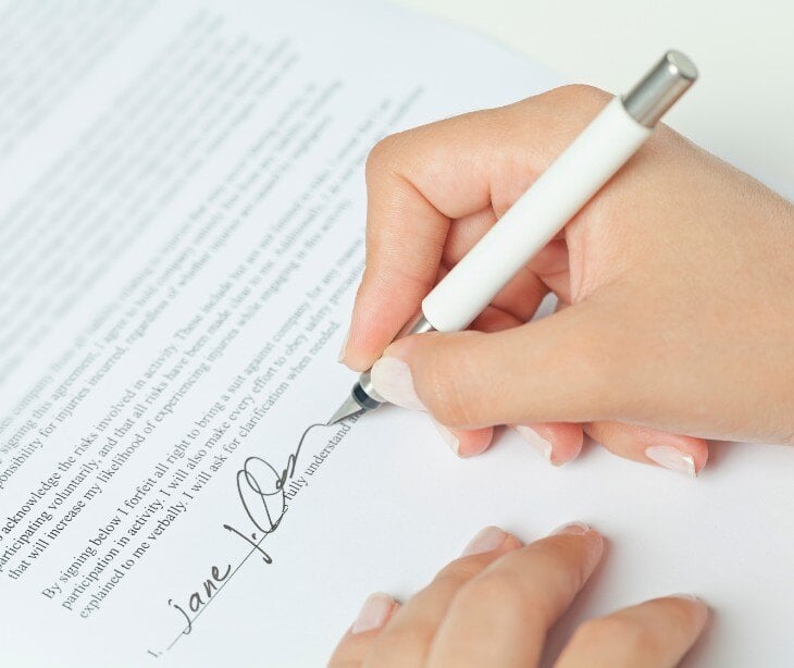 Individual signing a document for blog about Does signing a BAA automatically make a vendor HIPAA compliant?