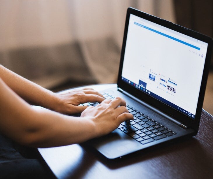 Image of someone typing on a computer for blog about Why psychiatrists should care about their background in virtual sessions