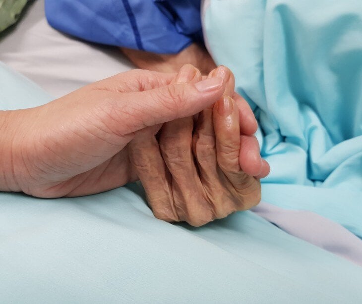 Image of two people holding hands for blog about HIPAA email for end-of-life care