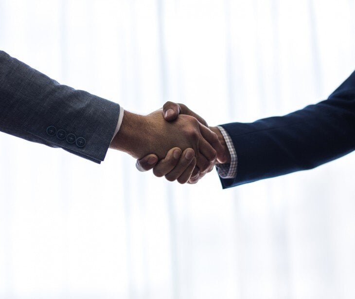 Image of two people shaking hands for blog about Are cybersecurity firms business associates?