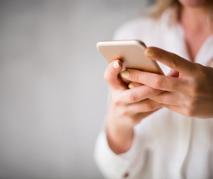 Image of someone on their phone for blog about Protecting patient privacy on social media