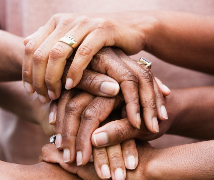 Image of women's hands layered on top of each other. 