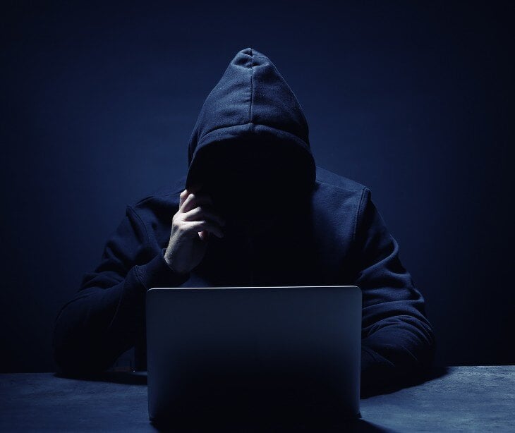 dark figure in front of laptop