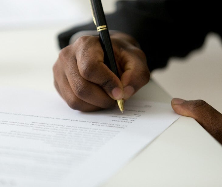 Image of someone signing a paper contract.