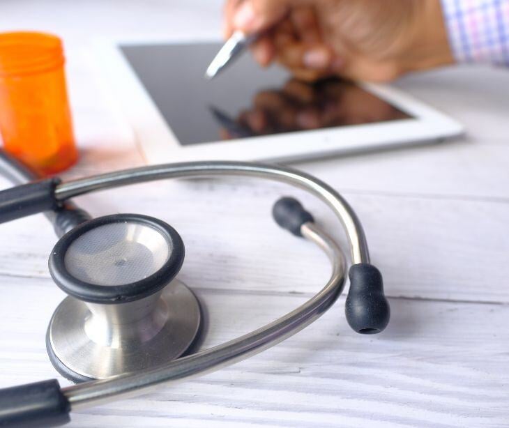 stethoscope and tablet with prescription bottle