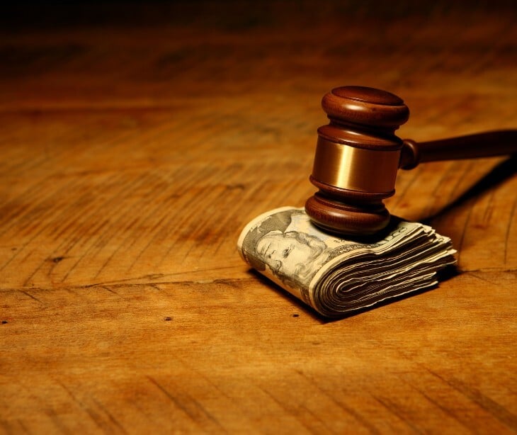 Image of a gavel over some money.