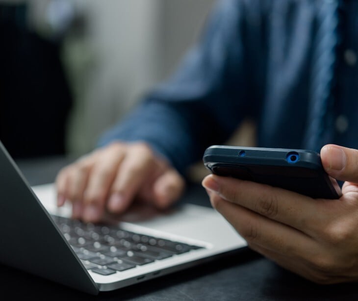 hands and smartphone on keyboard