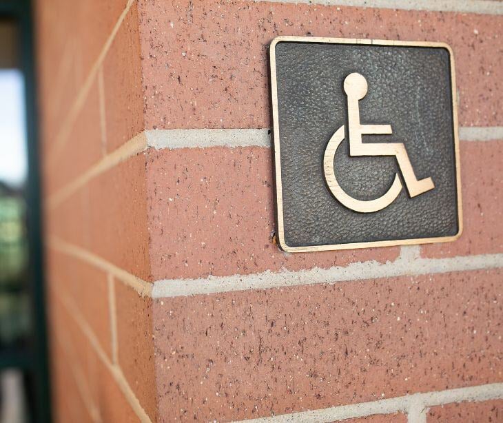 wheelchair sign on building for post The intersection between HIPAA and the Americans with Disabilities Act (ADA)