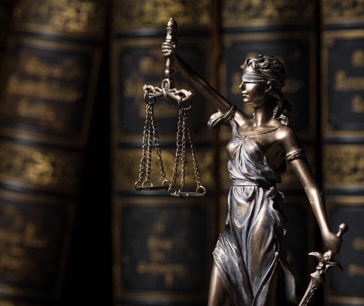 Image of lady justice, a woman holding a scale.