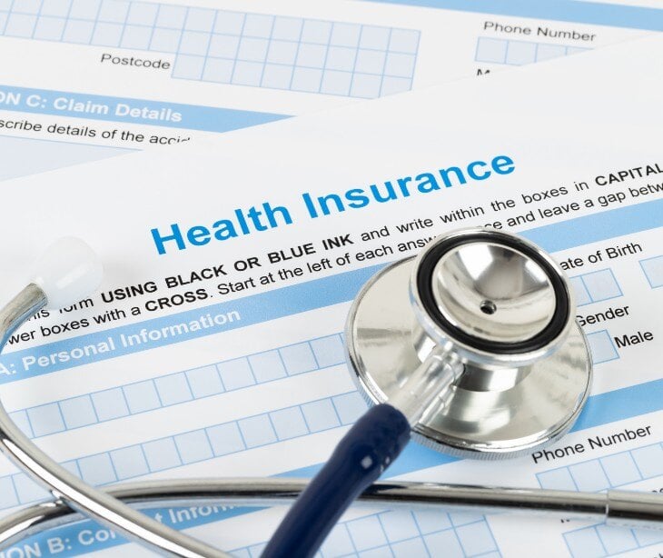 Image of stethescope over health insurance paperwork. 