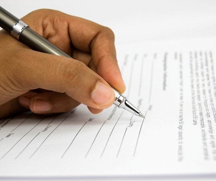 Image of individual signing an intake form.
