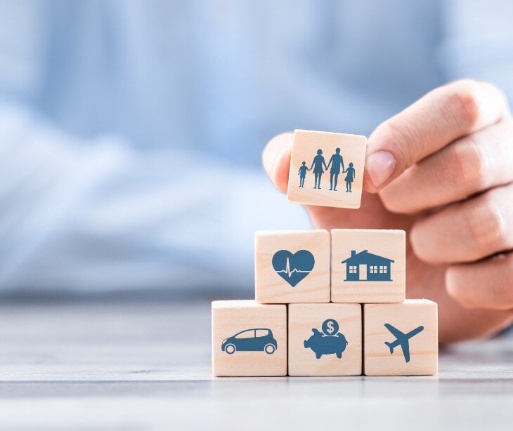 Image of blocks with an image of family, heart, home, piggybank, and plane.