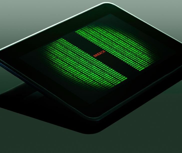 tablet with green data and red breach text