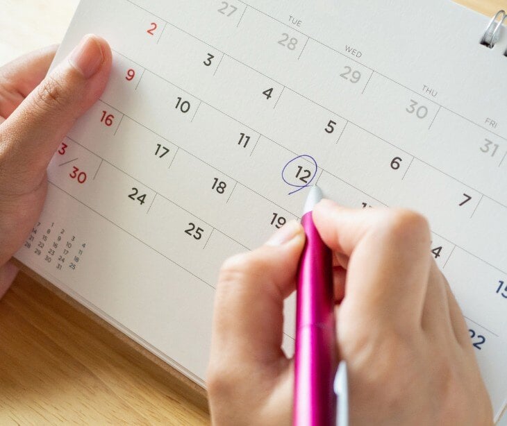 Image of someone writing on a calendar.