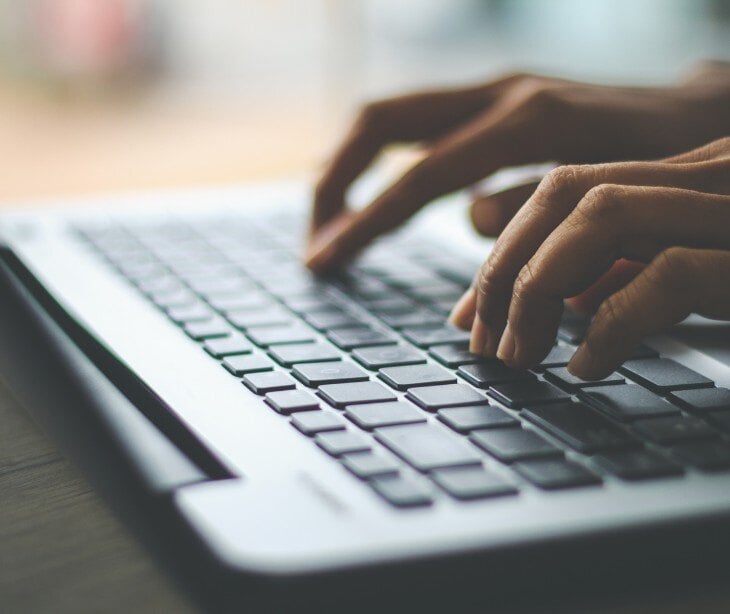 Image of someone typing on a laptop.