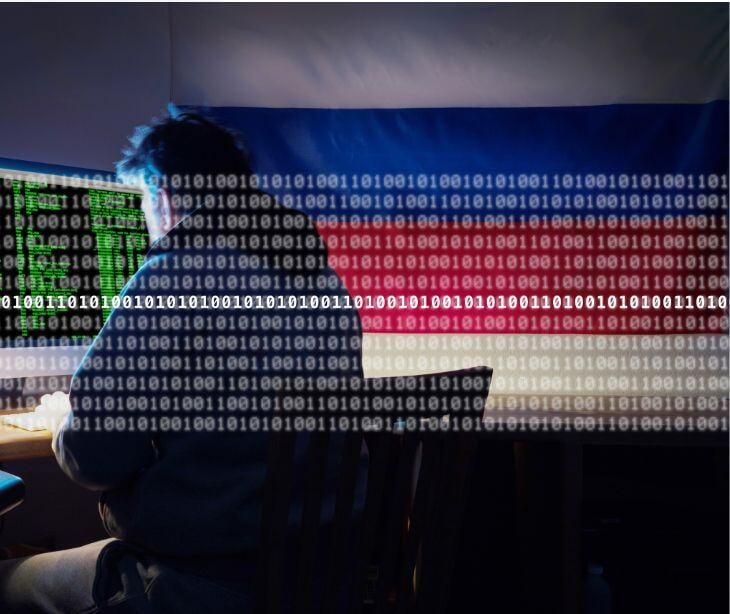 hacker at computer with digital code and russian flag