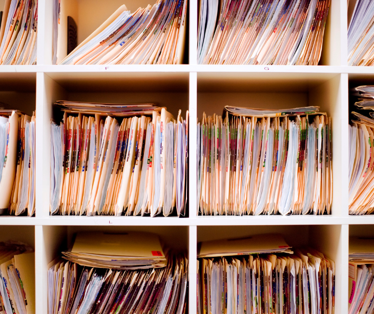 shelves of paper medical records for post Why certain hospitals have a higher risk of violating HIPAA 